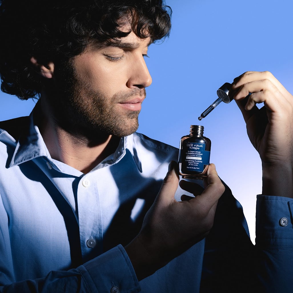 Homme tenant le s&eacute;rum revitalisant fortifiant dans la main