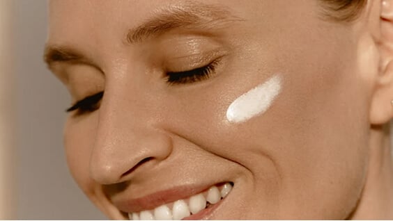 Mannequin à la peau mature sous une lumière solaire avec de la crème Sunleÿa sur la pommette
