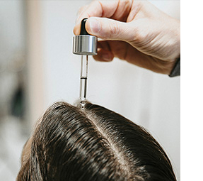 Nanesení séra Revatilizing Fortifying Serum z řady Hair Rituel By Sisley na vlasovou pokožku 