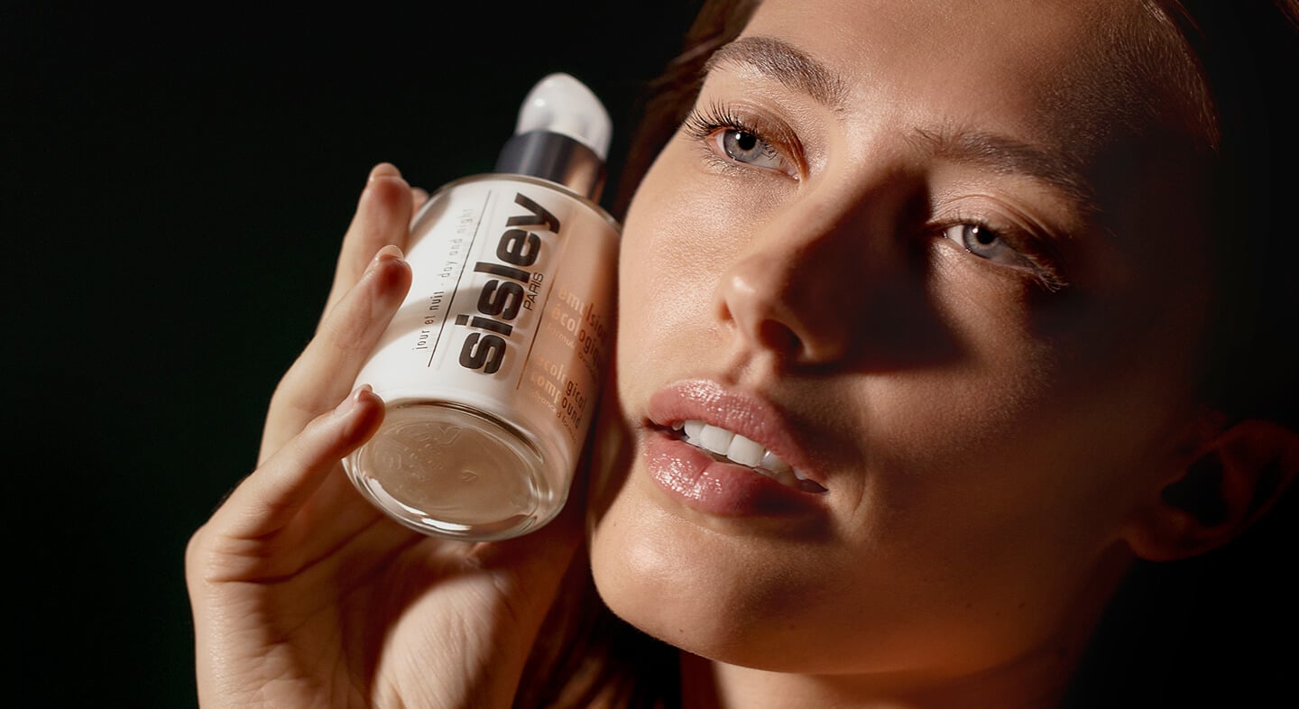 Femme tenant le flacon de l'Émulsion Écologique formule avancée de Sisley