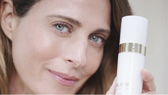 Femme à la peau mature tenant le flacon du Sérum Essentiel Longévité Sisleÿa L'Intégral Anti-Âge de Sisley Paris