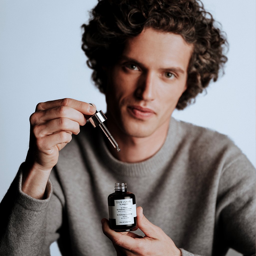 Ein Mann h&auml;lt Le S&eacute;rum Revitalisant Fortifiant in der Hand